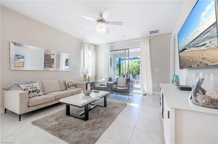 Living room featuring light tile patterned floors and ceiling fan