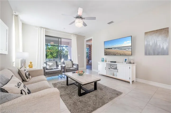 Living room featuring a ceiling fan and light tile patterned floors
