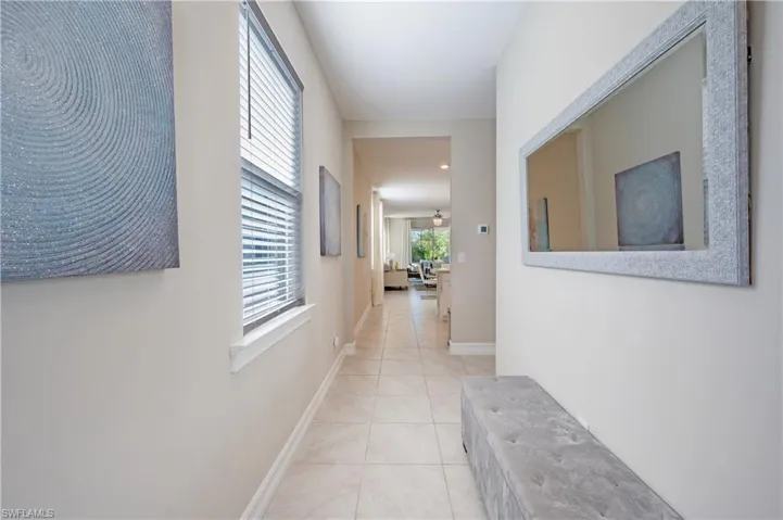 Corridor with baseboards and light tile patterned floors
