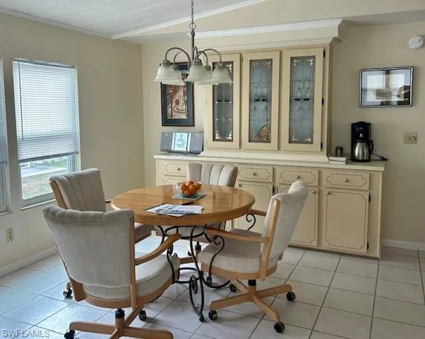 Dining space with light tile patterned floors and a chandelier