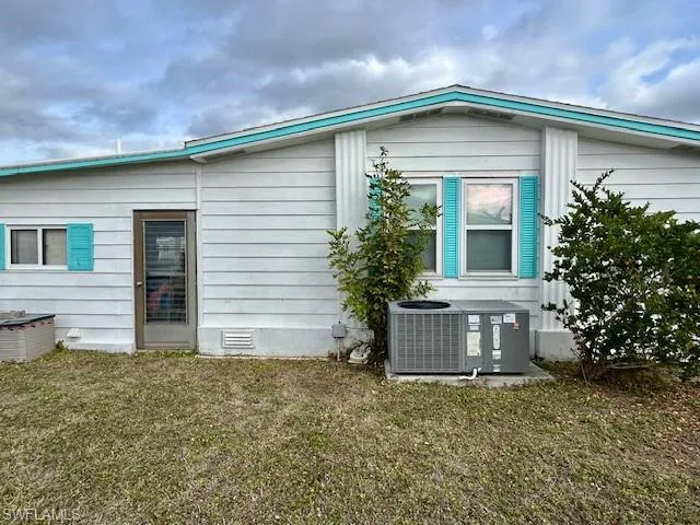 View of home's exterior with crawl space and a yard