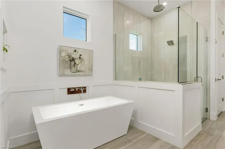 Bathroom featuring independent shower and bath and hardwood / wood-style flooring