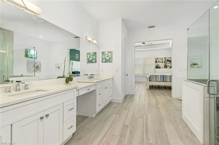Bathroom with hardwood / wood-style floors, an enclosed shower, and vanity