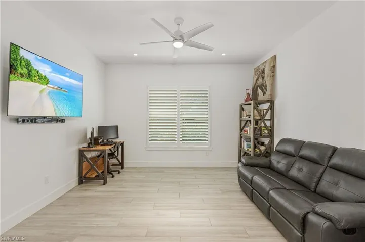 Living room featuring ceiling fan and light hardwood / wood-style flooring