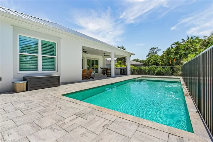 View of swimming pool with ceiling fan, a patio area, and pool water feature
