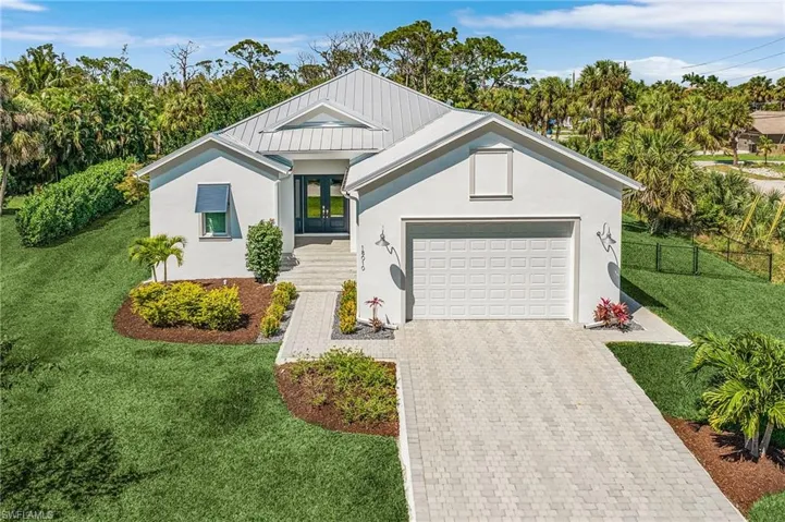 View of front facade featuring a garage and a front yard