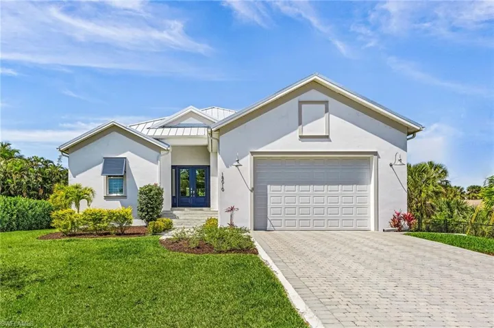 View of front of home with a front lawn, a garage, and french doors