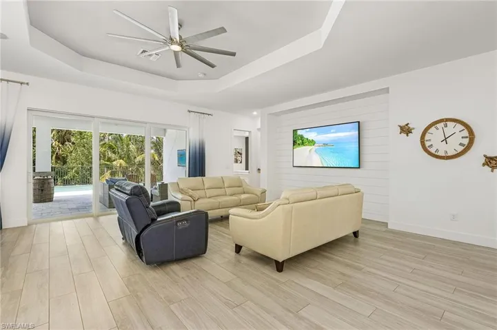 Living room with ceiling fan and a tray ceiling