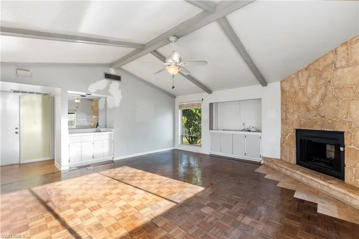 Unfurnished living room with a stone fireplace and ceiling fan