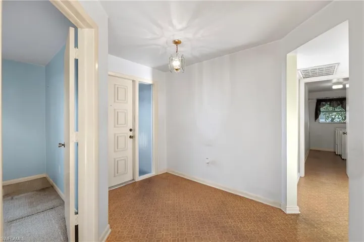 Carpeted spare room with a chandelier and ceiling fan