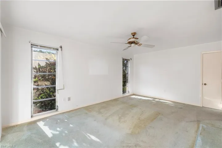 Spare room with a ceiling fan, carpet flooring, and a chandelier