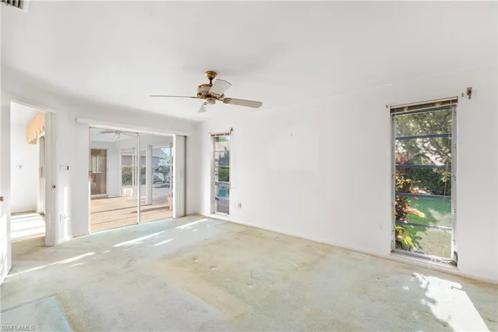 Carpeted empty room with healthy amount of natural light and ceiling fan