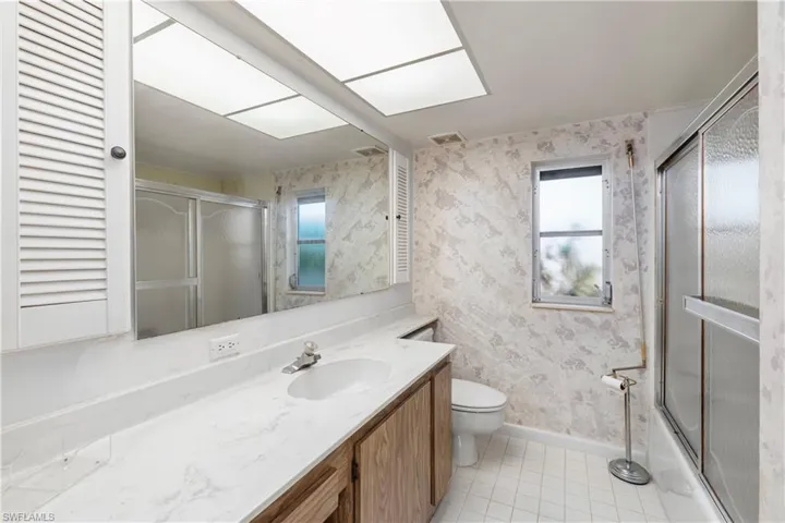 Full bathroom with tile patterned floors, vanity, and a stall shower