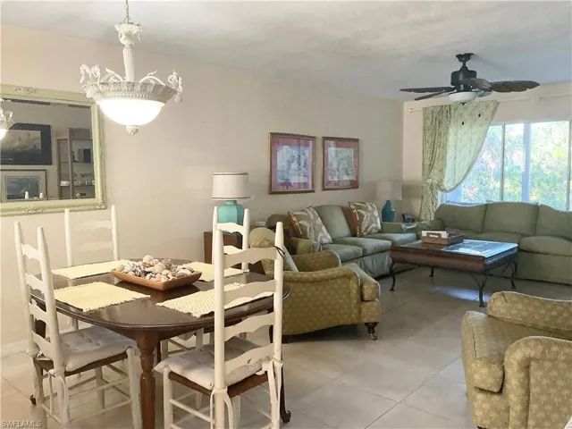Dining and living area with light tile, ceiling fan & TV