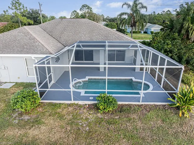Rear view of house with a lanai and pool
