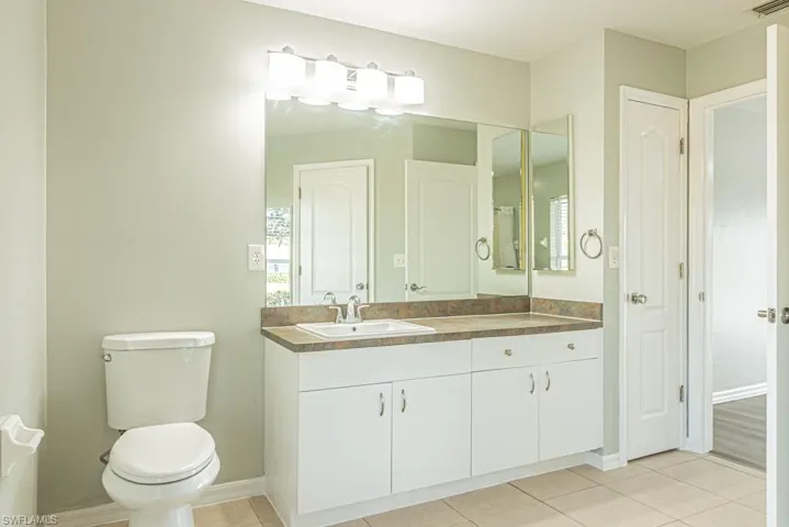 Full bath featuring vanity and light tile