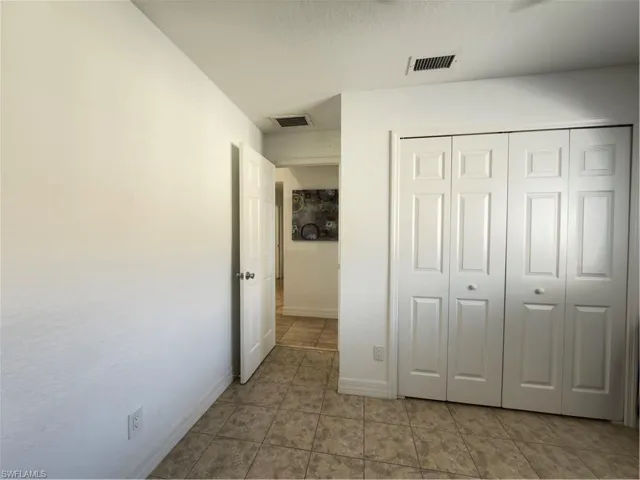 Unfurnished bedroom featuring a closet and light tile patterned floors
