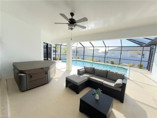 View of patio / terrace with outdoor seating, an outdoor pool, glass enclosure, a sunroom, and a ceiling fan