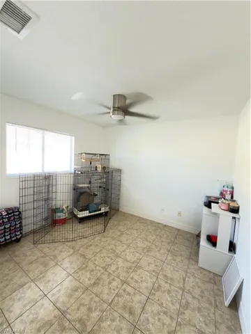 Sitting room featuring a ceiling fan and light tile patterned floors