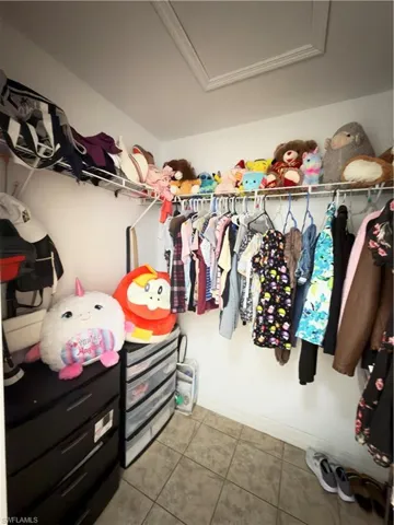 Walk in closet with light tile patterned floors