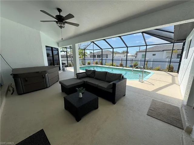 Fenced backyard featuring a patio area, a sunroom, ceiling fan, a lanai, and an outdoor living space