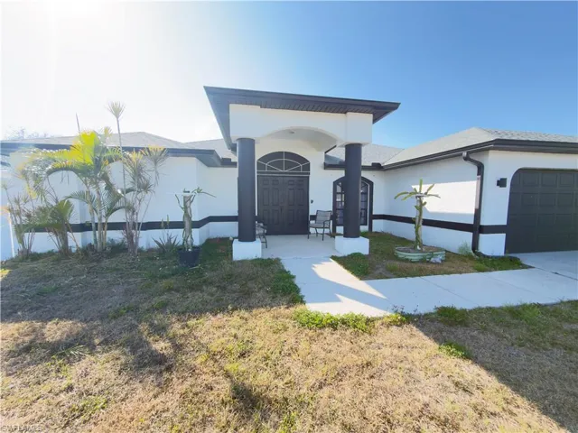 Ranch-style house featuring an attached garage, stucco siding, and a front yard