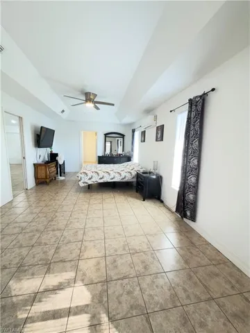 Bedroom with ceiling fan and light tile patterned floors