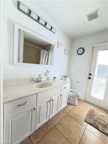 Bathroom featuring vanity, a shower with curtain, and light tile patterned floors