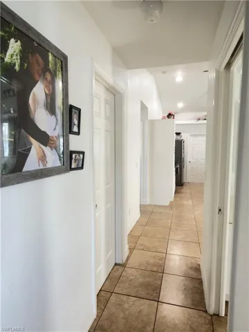 Corridor with light tile patterned flooring and recessed lighting