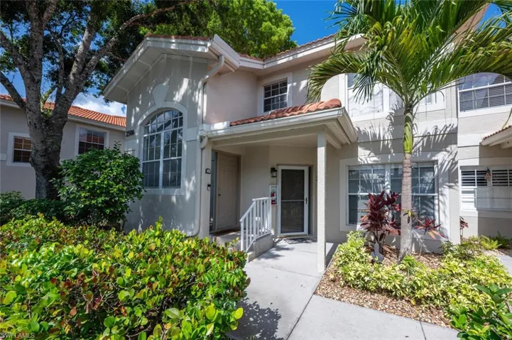 Mediterranean / spanish-style house with a tile roof, stucco siding, and a porch