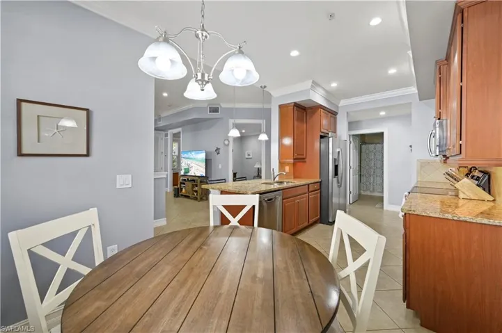 Dining space featuring light tile patterned flooring, visible vents, and ornamental molding