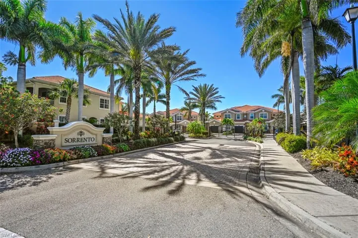 View of road featuring street lighting, a gated entry, a residential view, curbs, and a gate
