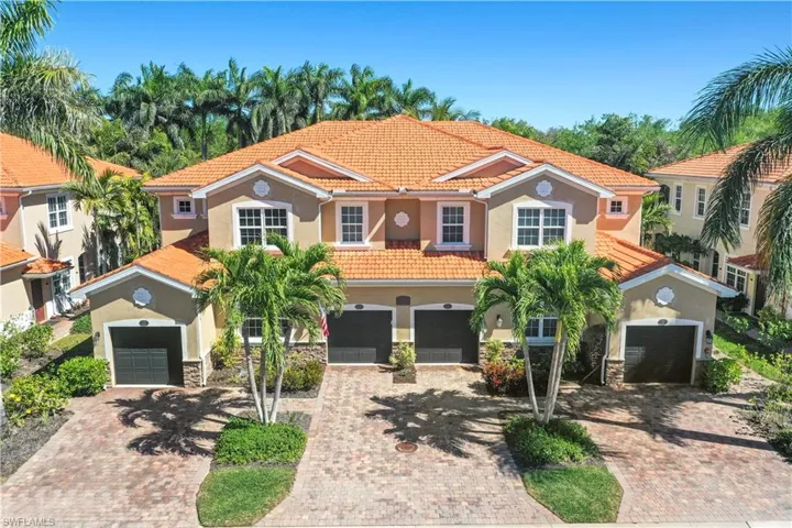 Mediterranean / spanish-style home featuring a tiled roof, decorative driveway, stone siding, and stucco siding
