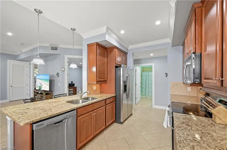Kitchen featuring granite countertops and solid wood cabinets. Crown molding throughout