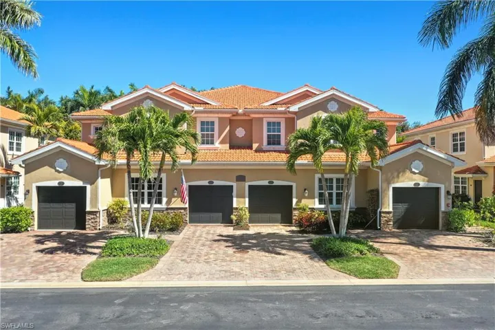 Mediterranean / spanish home with a tiled roof, stone siding, stucco siding, and driveway