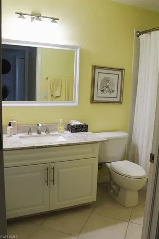 Bathroom with vanity, a shower with curtain, and light tile patterned flooring