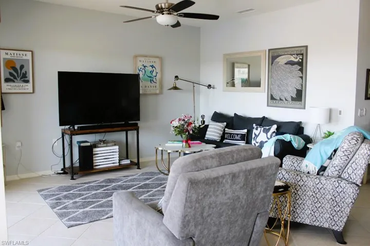 Living area featuring tile patterned floors and ceiling fan