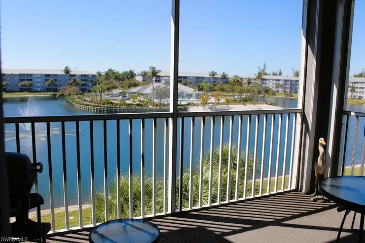 Balcony featuring a water view, a sunroom, and a grill