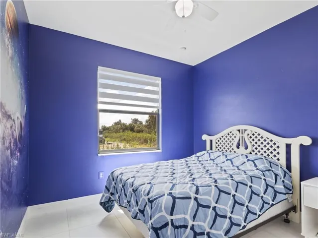 Bedroom featuring a ceiling fan and light tile patterned flooring