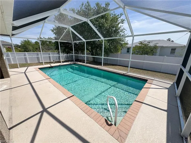 View of pool featuring a fenced in pool, a patio, glass enclosure, and a fenced backyard