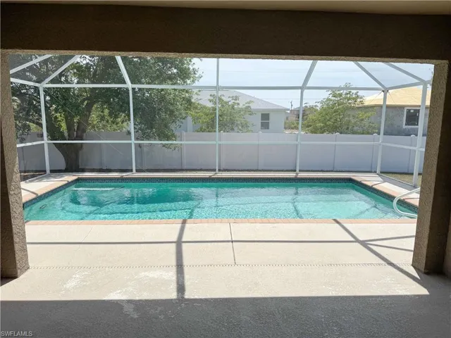 View of pool with a fenced in pool, a patio, glass enclosure, and fence
