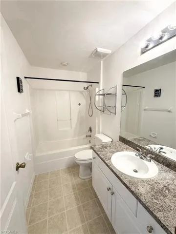 Full bath featuring vanity, visible vents, tile patterned flooring, bathing tub / shower combination, and toilet