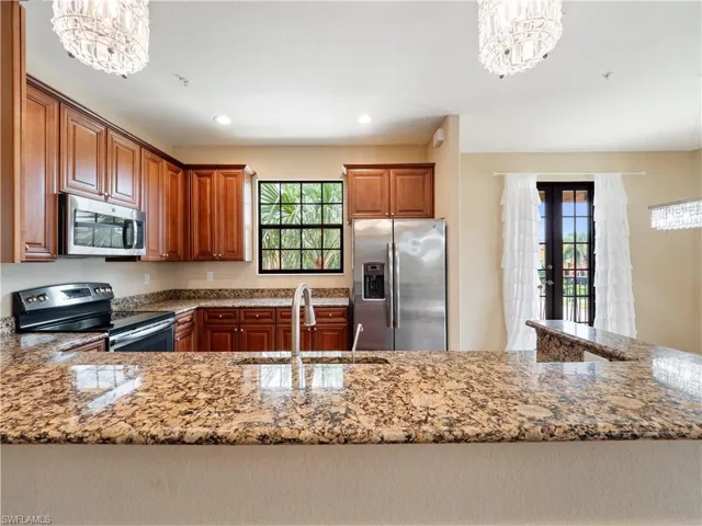 Kitchen with pendant lighting, an inviting chandelier, sink, and appliances with stainless steel finishes