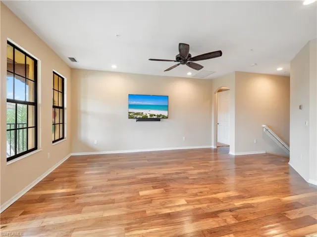 Unfurnished living room featuring ceiling fan and light hardwood / wood-style flooring