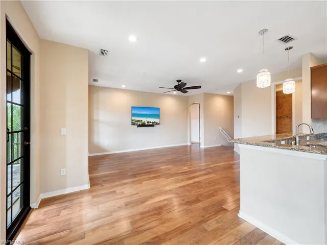 Unfurnished living room with light wood-type flooring, sink, and ceiling fan