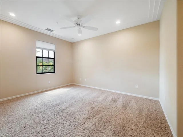 Spare room featuring carpet and ceiling fan