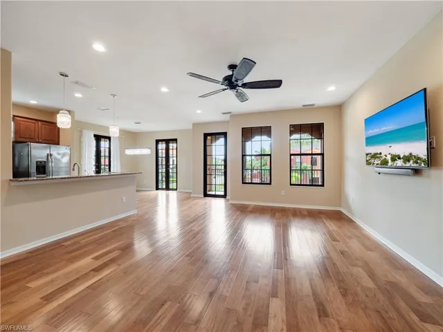 Unfurnished living room with ceiling fan, sink, and light hardwood / wood-style floors