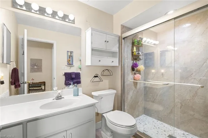 Bathroom with a stall shower, toilet, and vanity