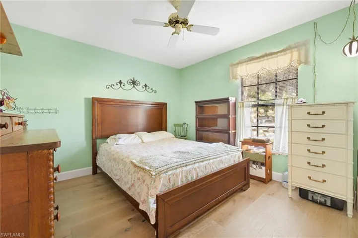 Bedroom with baseboards, a ceiling fan, and light wood-type flooring