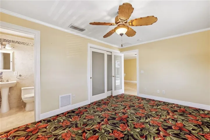 The Aruba unit Primary Bedroom with ensuite bath, carpet flooring, closet, and ceiling fan